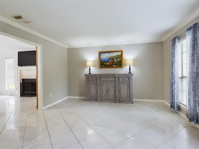 unfurnished living room featuring ornamental molding and light tile patterned flooring