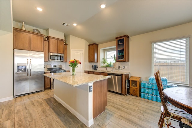 2446 Wembley Way, Rosenberg, TX 77471 - kitchen with stainless steel appliances, a sink, tasteful backsplash, light wood-type flooring, and lofted ceiling