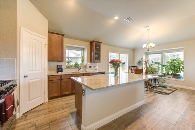 2446 Wembley Way, Rosenberg, TX 77471 - kitchen with a sink, gas stove, lofted ceiling, a chandelier, and brown cabinetry