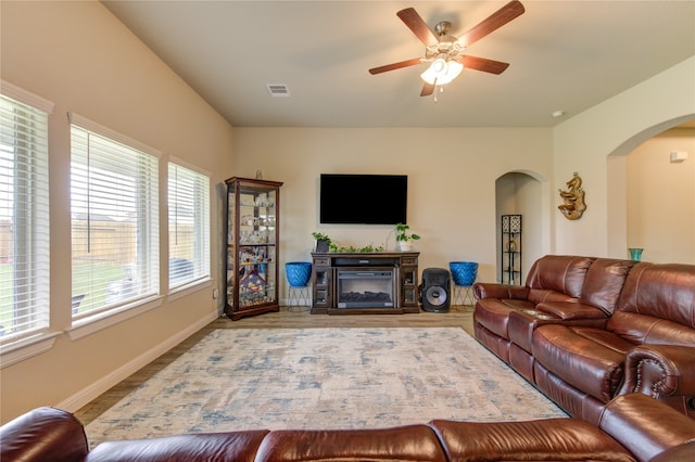 living room featuring light hardwood / wood-style flooring, a fireplace, and ceiling fan