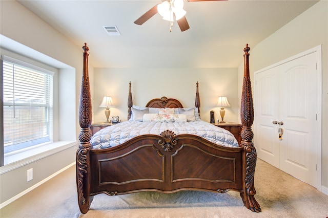 bedroom with light colored carpet, a closet, and ceiling fan