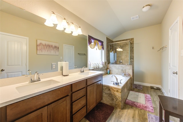 bathroom featuring vanity, shower with separate bathtub, wood-type flooring, and vaulted ceiling