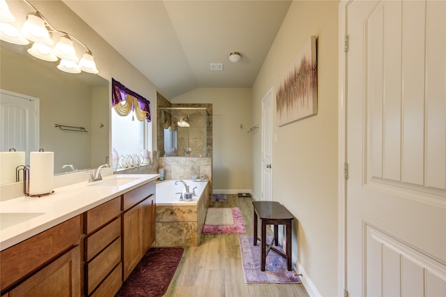 bathroom featuring vanity, independent shower and bath, hardwood / wood-style floors, and vaulted ceiling