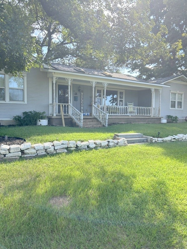 view of front facade featuring covered porch and a front lawn