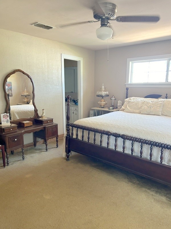 carpeted bedroom with connected bathroom and ceiling fan