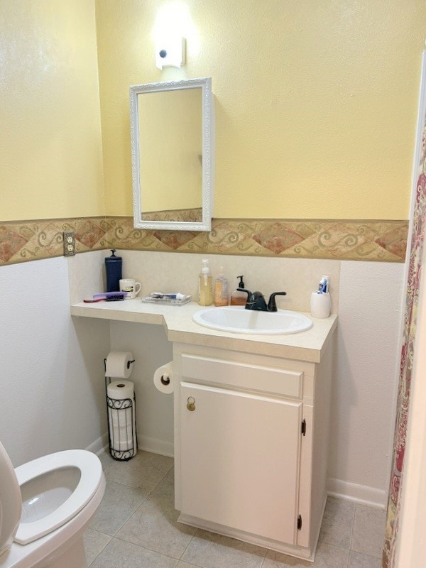 bathroom featuring vanity, toilet, and tile patterned flooring