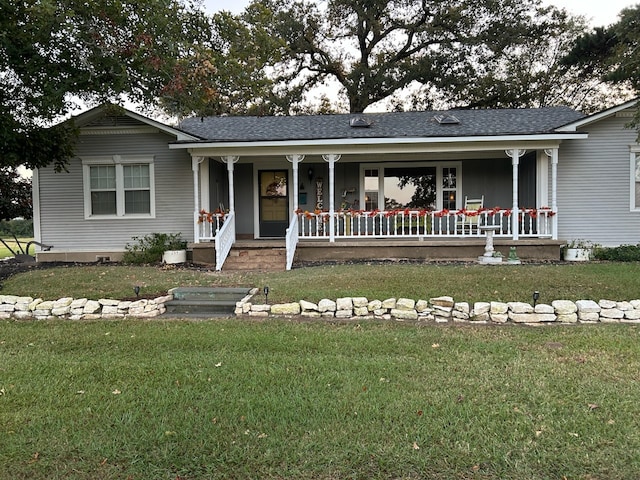 single story home with roof with shingles, covered porch, and a front lawn