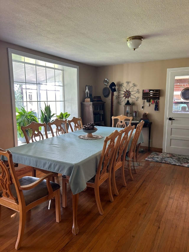 dining space with a textured ceiling and wood-type flooring