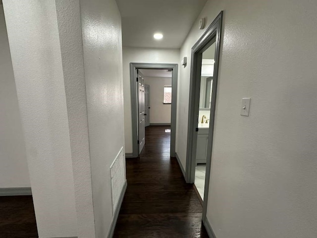 corridor with sink and dark hardwood / wood-style flooring