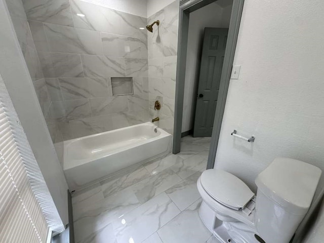 bathroom with tiled shower / bath combo and toilet