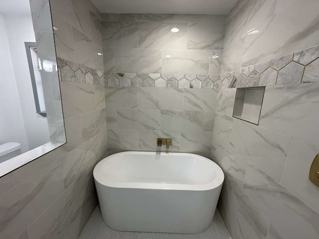 bathroom featuring a bathing tub and tile walls