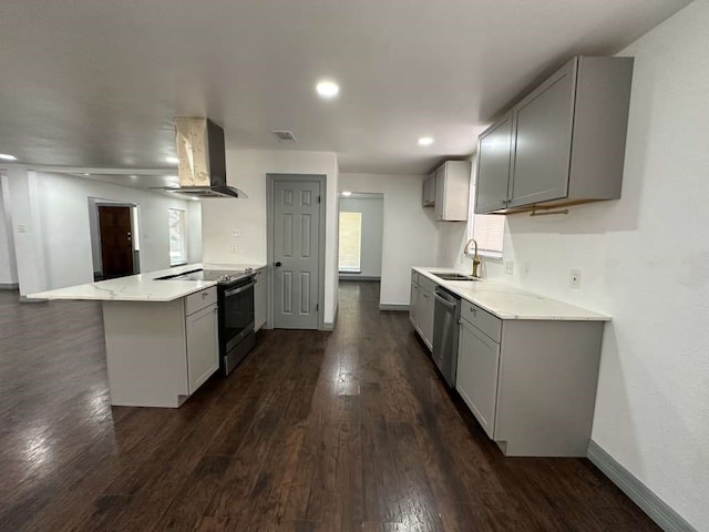 kitchen with wall chimney exhaust hood, gray cabinetry, sink, stainless steel appliances, and kitchen peninsula