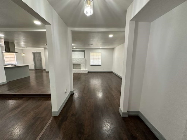 interior space with a brick fireplace and dark hardwood / wood-style floors