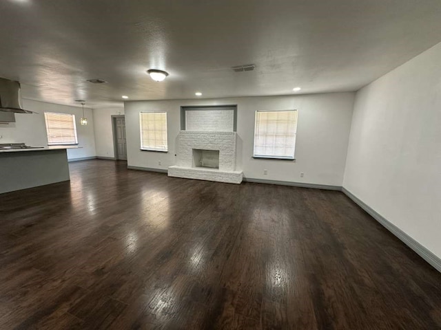 unfurnished living room with plenty of natural light and dark hardwood / wood-style floors