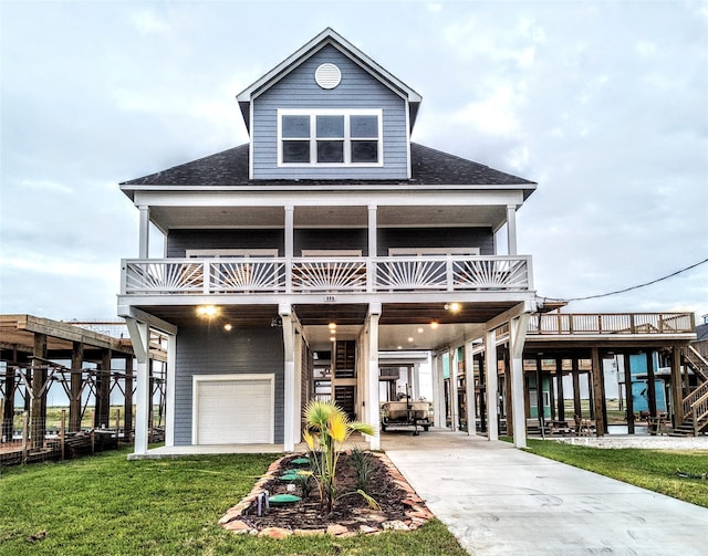 coastal inspired home featuring a front yard, a garage, and a carport