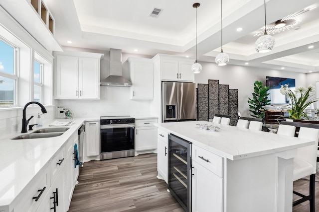 555 Pompano Dr Unit Q, Freeport, TX 77541 - kitchen with stainless steel appliances, wine cooler, a sink, visible vents, and wall chimney range hood
