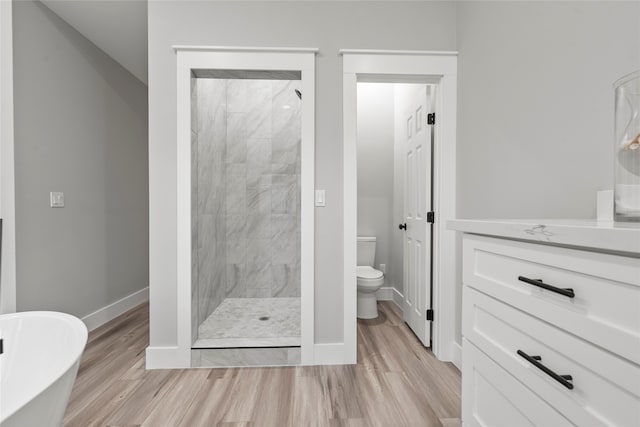 full bathroom with vanity, wood-type flooring, shower with separate bathtub, and toilet