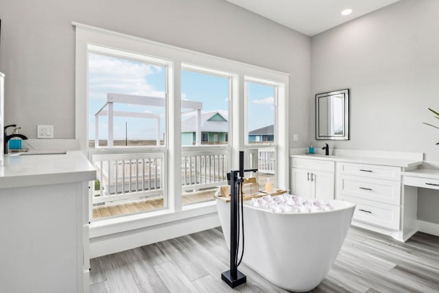 555 Pompano Dr Unit Q, Freeport, TX 77541 - interior space with a freestanding bath, vanity, wood finished floors, and recessed lighting