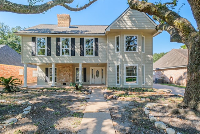 colonial home featuring central air condition unit and a porch