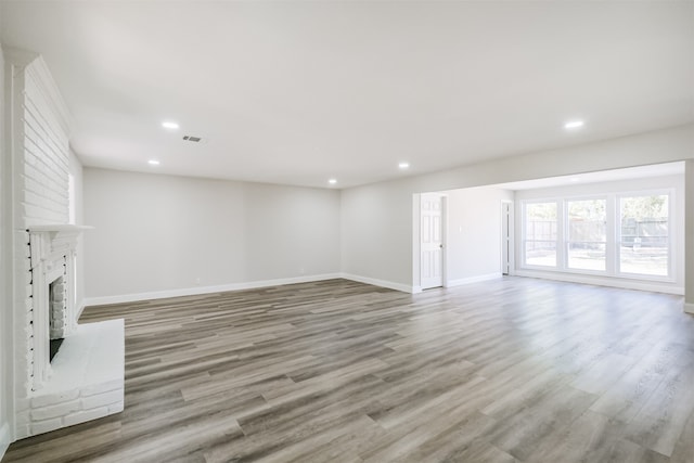 unfurnished living room with a fireplace and light wood-type flooring