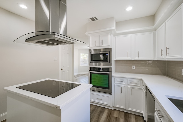 kitchen with white cabinetry, island exhaust hood, stainless steel appliances, and tasteful backsplash