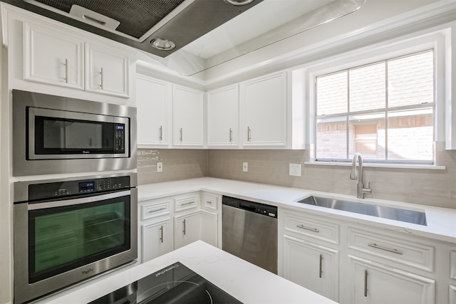 kitchen featuring sink, appliances with stainless steel finishes, decorative backsplash, and white cabinets