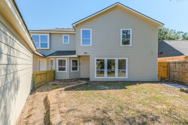 rear view of property featuring a lawn