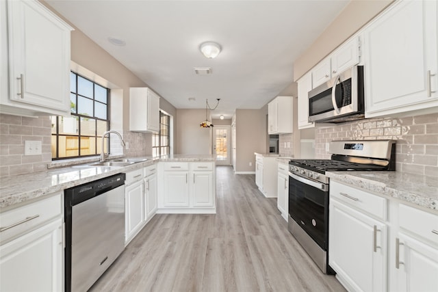 kitchen featuring sink, appliances with stainless steel finishes, light hardwood / wood-style flooring, and white cabinetry