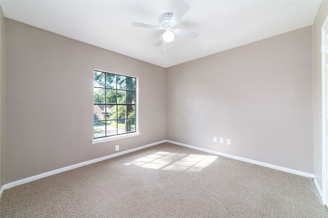 carpeted spare room with ceiling fan