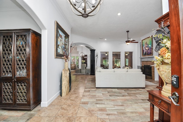 living room featuring ceiling fan, a fireplace, and crown molding