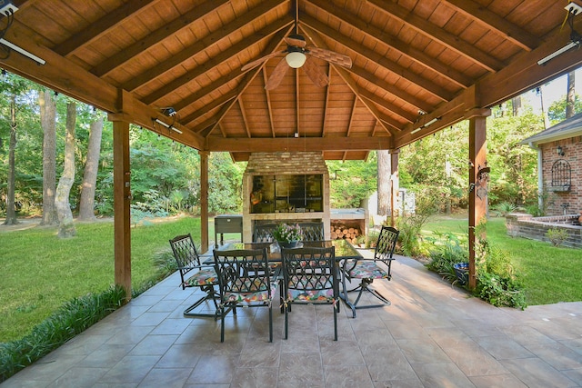 view of patio featuring a gazebo, ceiling fan, and an outdoor brick fireplace