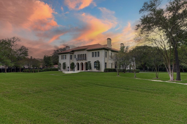 rear view of house with a lawn and a chimney