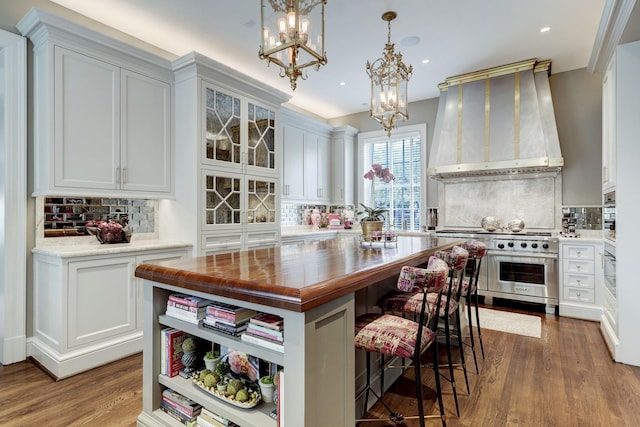 kitchen with wall chimney range hood, decorative backsplash, and appliances with stainless steel finishes