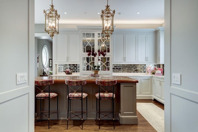 bar with tasteful backsplash, pendant lighting, and dark wood-style flooring