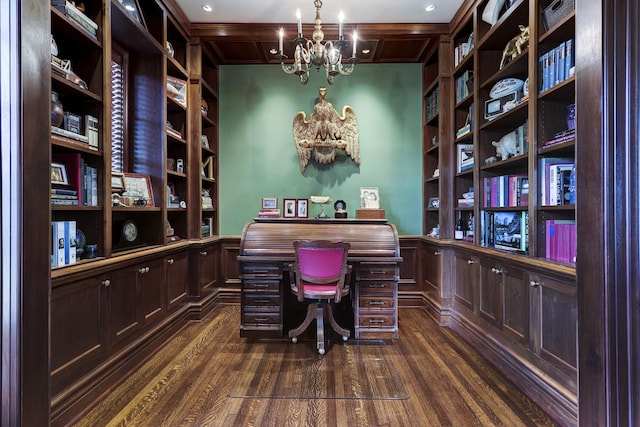 office space featuring dark wood-type flooring, a notable chandelier, built in desk, and wainscoting