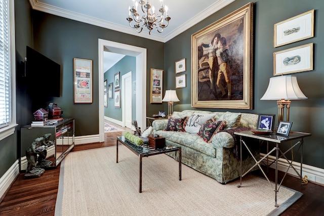 living room with wood-type flooring, ornamental molding, and a chandelier