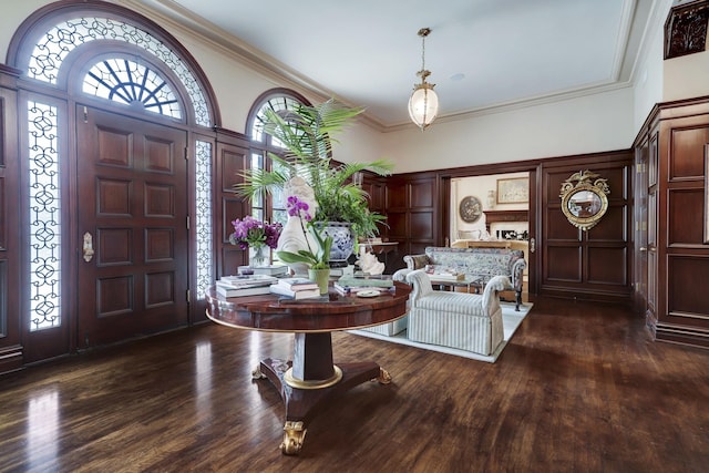 foyer with ornamental molding and wood finished floors