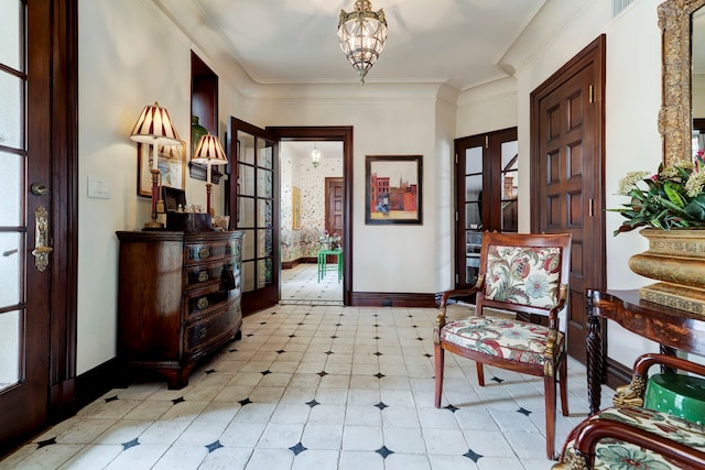 sitting room with french doors, a notable chandelier, crown molding, and a healthy amount of sunlight