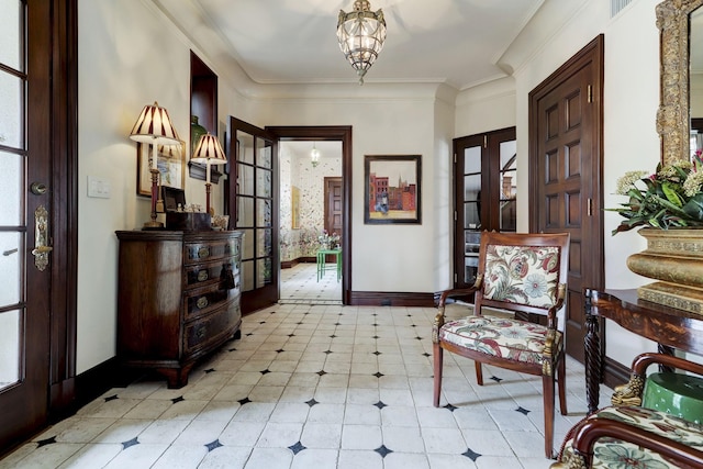 foyer entrance featuring ornamental molding, french doors, a notable chandelier, and baseboards