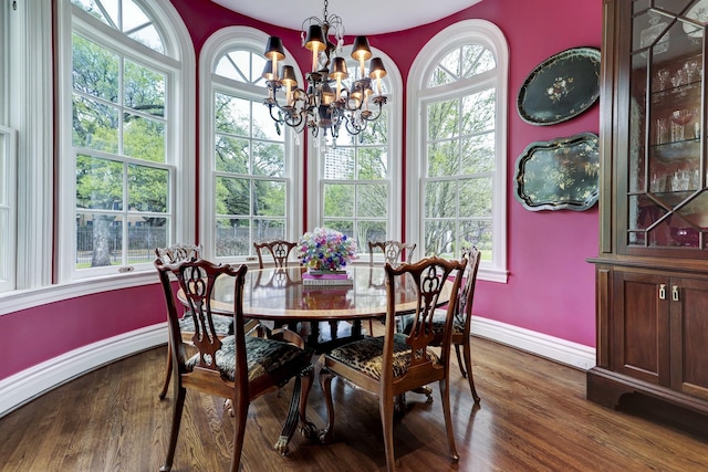dining room featuring dark wood-style floors, a notable chandelier, and baseboards