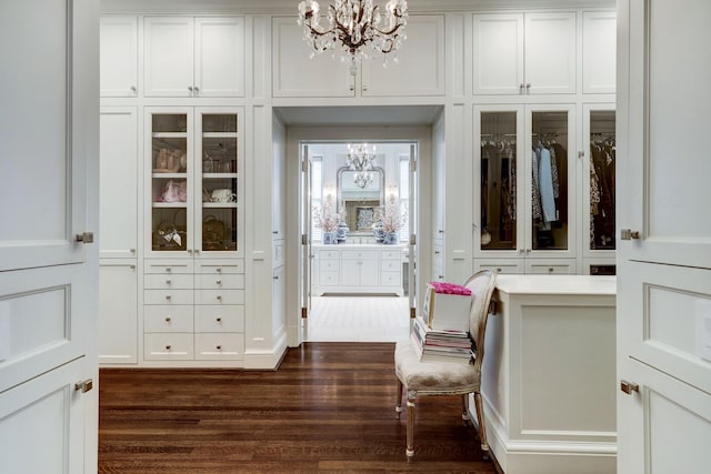 spacious closet featuring a notable chandelier and dark wood-style flooring