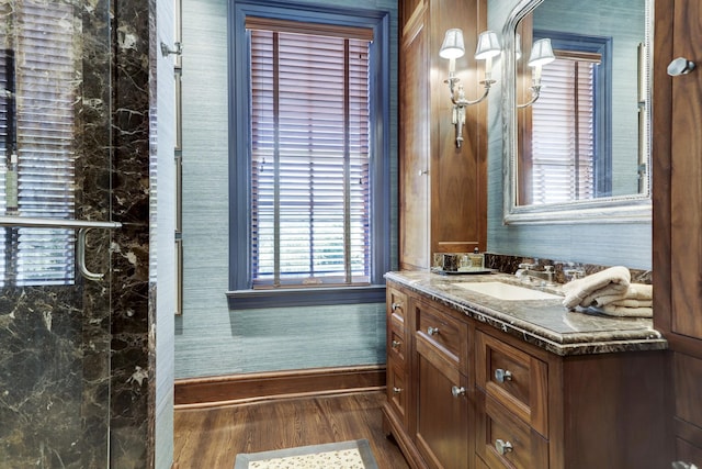 bathroom featuring baseboards, wood finished floors, and vanity