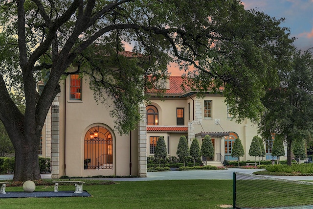 mediterranean / spanish-style home with stucco siding and a lawn