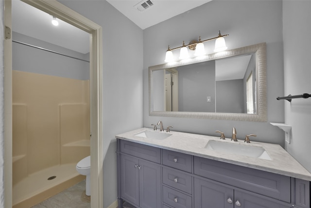 bathroom featuring tile patterned floors, vanity, toilet, and walk in shower