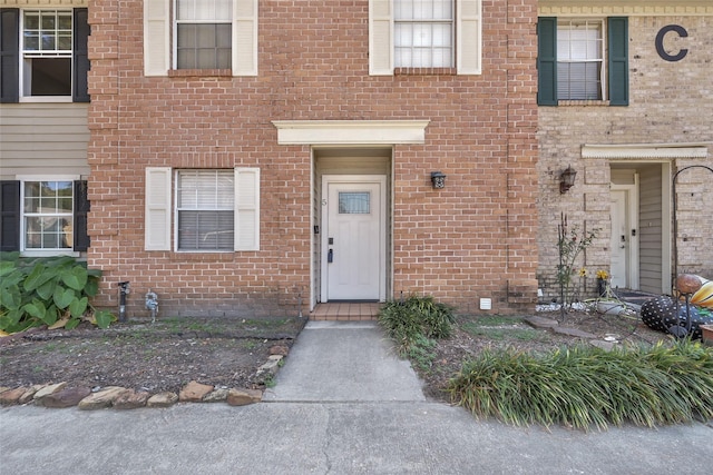 property entrance featuring brick siding