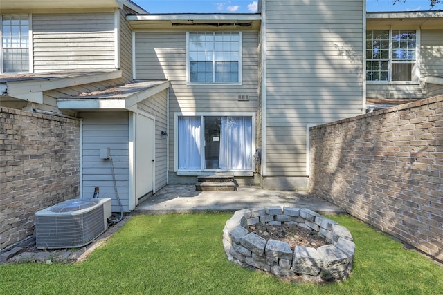 back of house featuring an outdoor fire pit and central air condition unit