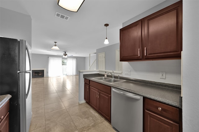 kitchen featuring pendant lighting, sink, ceiling fan, decorative backsplash, and stainless steel appliances