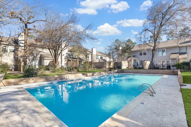 community pool featuring a residential view and fence