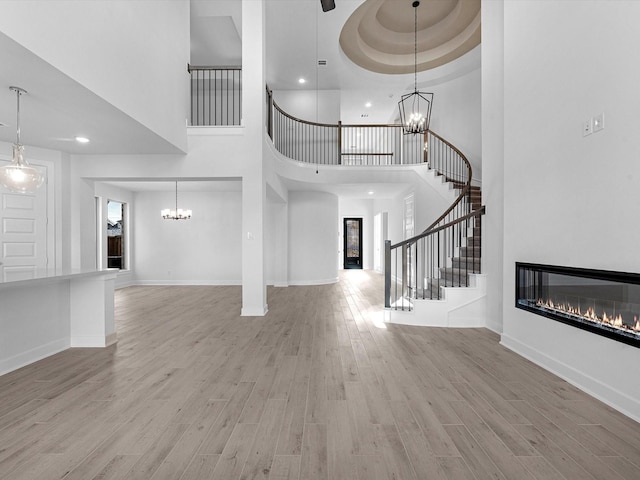 entryway featuring a high ceiling, a tray ceiling, and light hardwood / wood-style floors