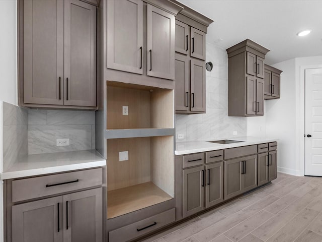 kitchen featuring gray cabinets, decorative backsplash, and light wood-type flooring